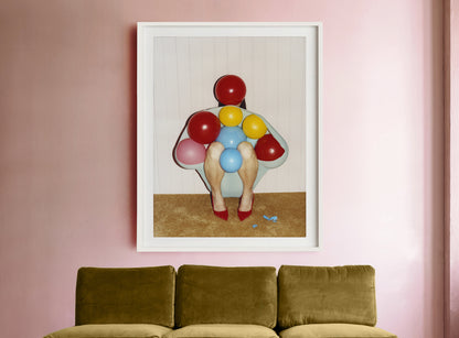 White wooden framed poster of a woman hiding behind the balloons hanged on a pink wall