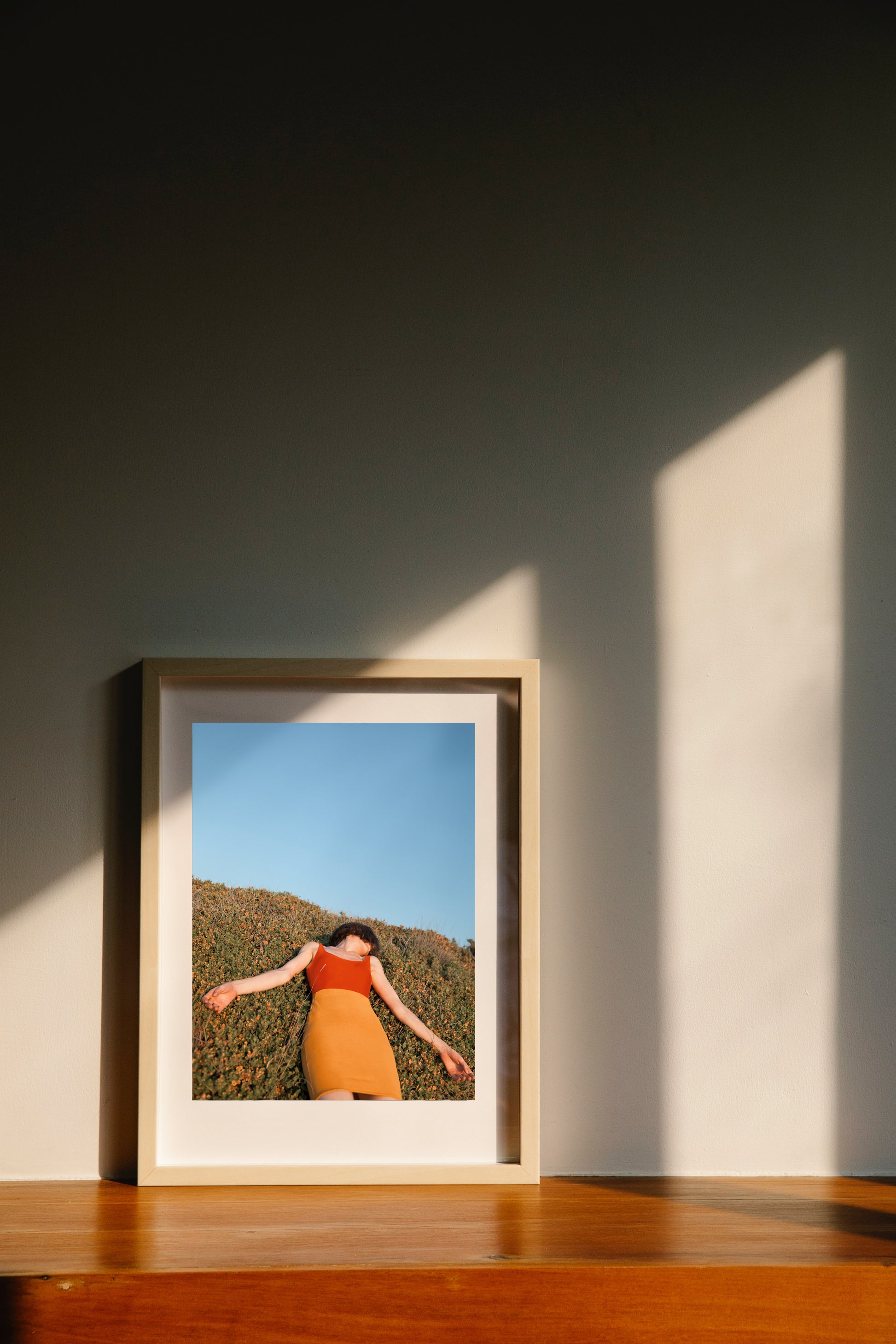 Wooden framed poster with a woman relaxing outdoors on a hot summer day.